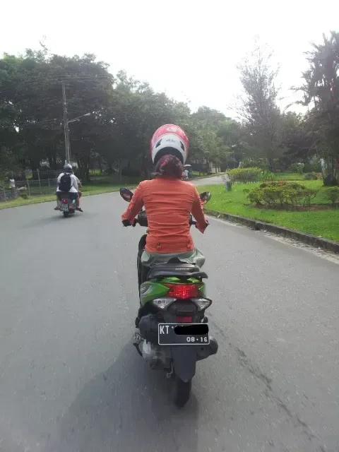 Contoh pemakaian helm yang tampak longgar karena tertahan lapisan kain hijab
