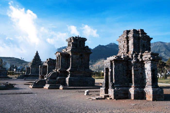 Kompleks Candi Pandawa di Dieng dengan latar belakang gunung